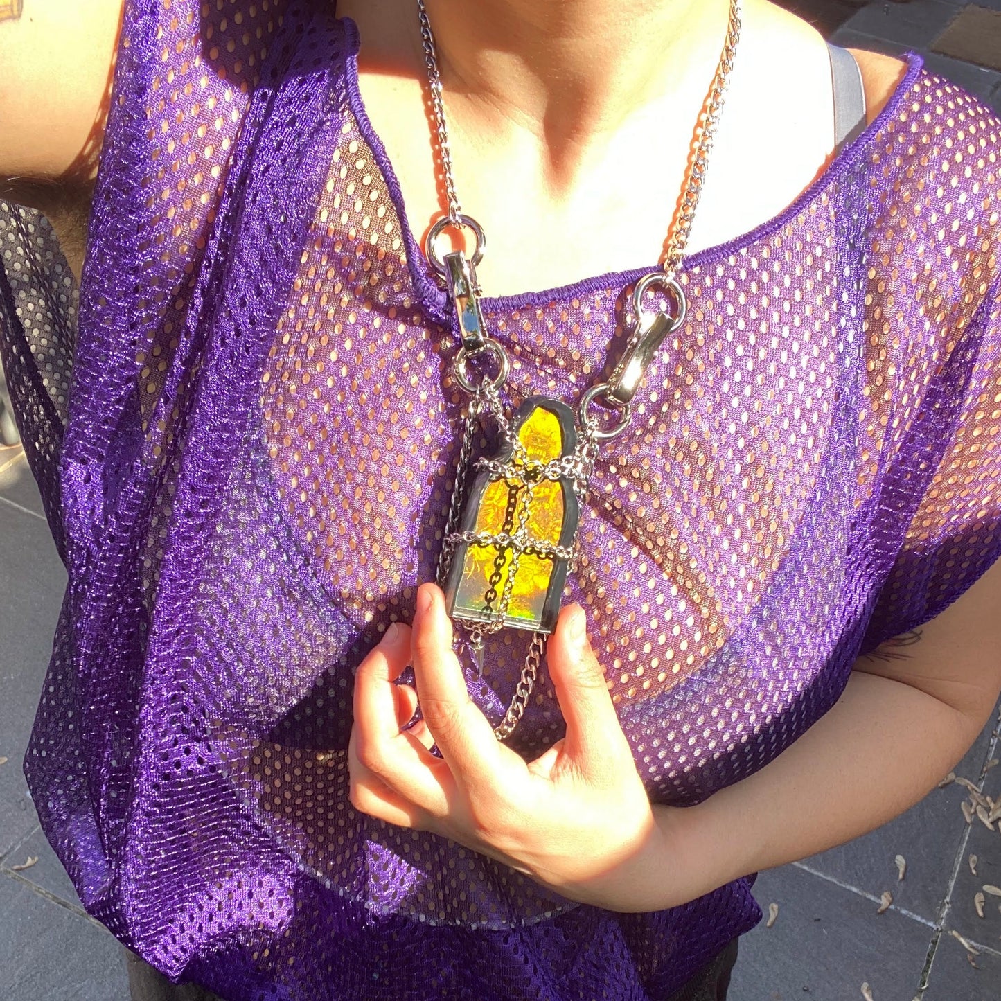 model wears holographic caged wolf pendant