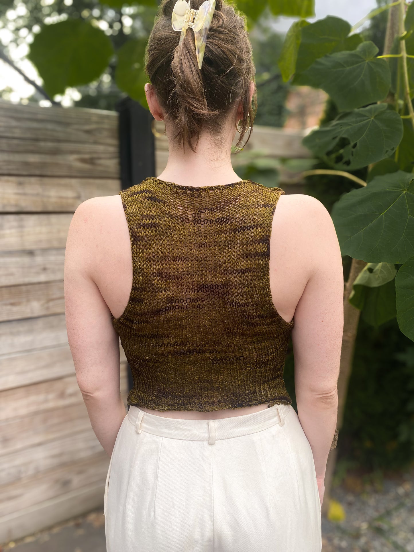 black and yellow large gage mesh front and wool knit back crop tank, back view