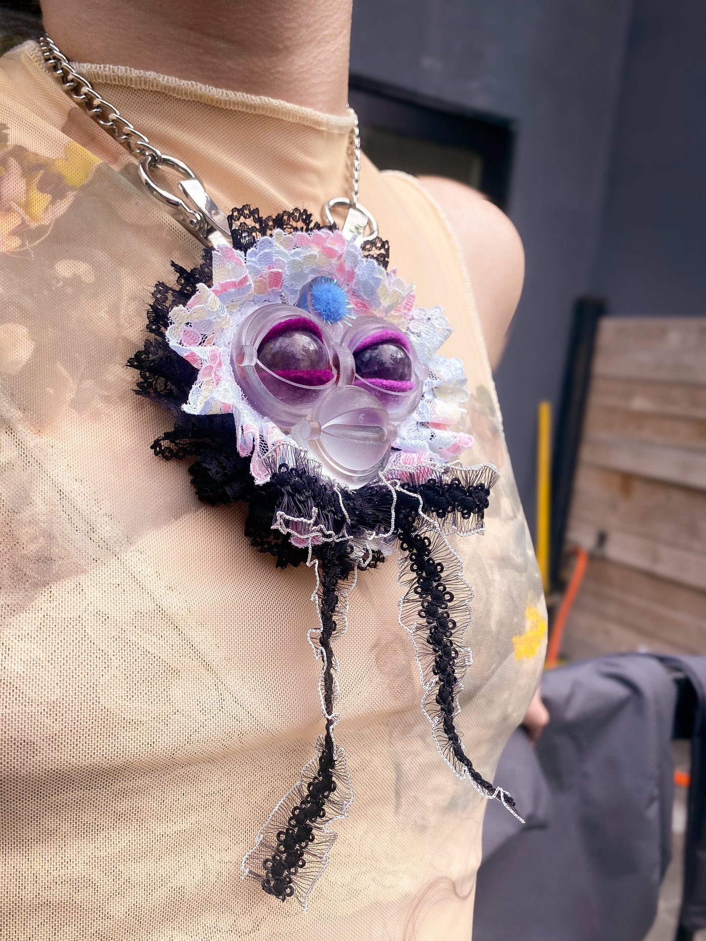 clear face pendant with amethyst eyes, white and black lace ruff, and white and black lace bow, 3/4 view
