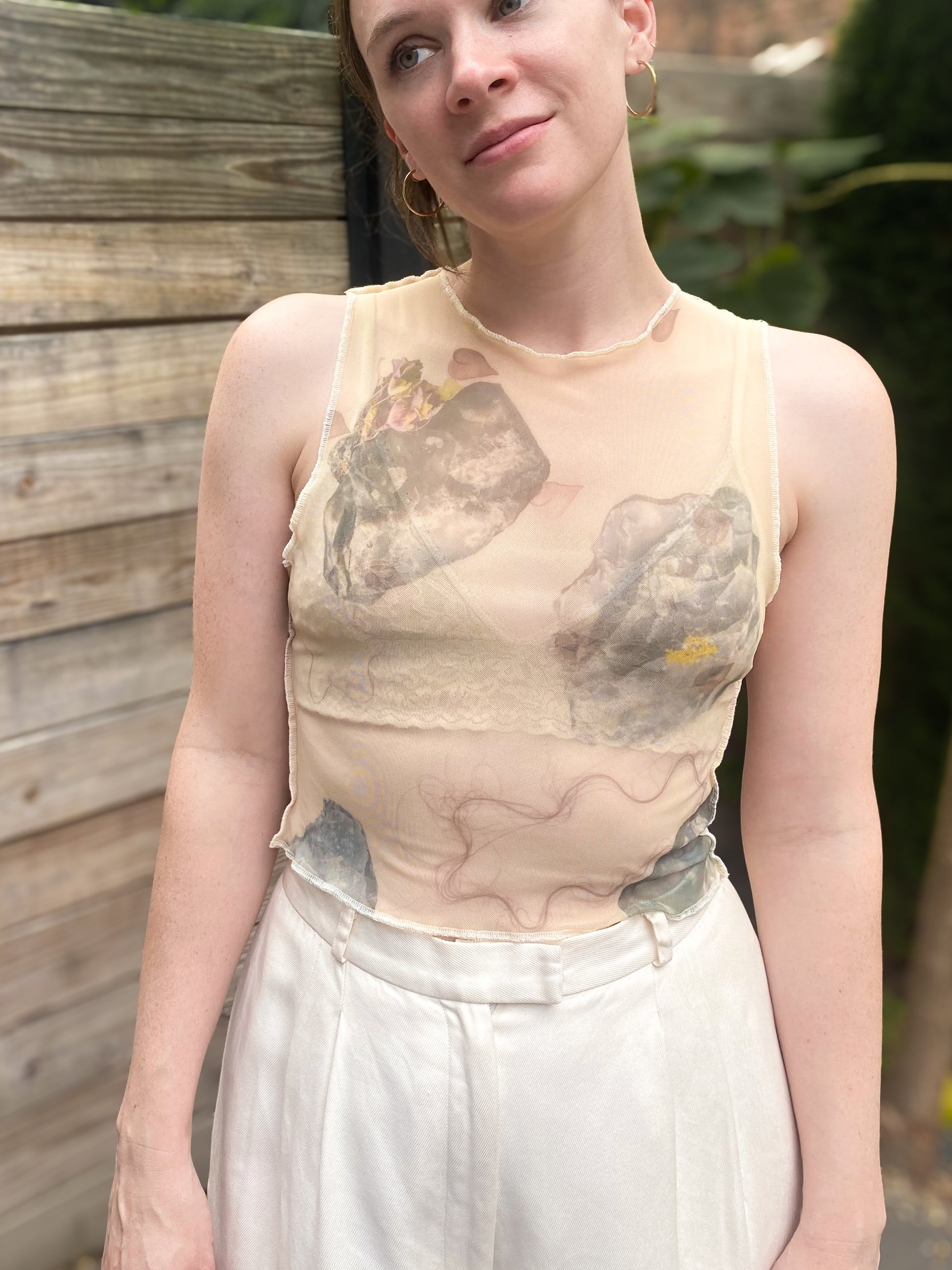 model wears beige mesh crop top with rock print