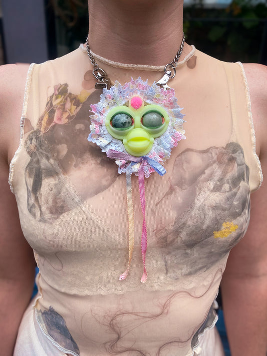 yellow face pendant with mossy agate and green adventurine eyes, pastel multi-colored lace ruff, and pastel rainbow bow, front view