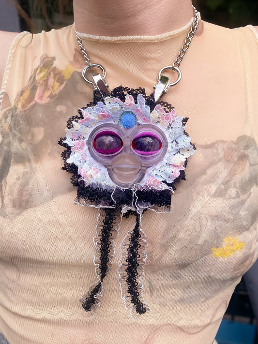 clear face pendant with amethyst eyes, white and black lace ruff, and white and black lace bow, front view