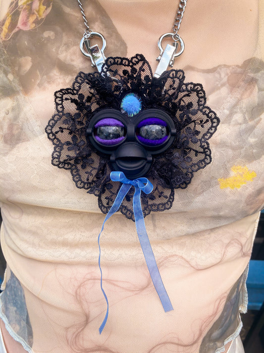 black face pendant with black labradorite eyes, black lace ruff, and blue bow, front view