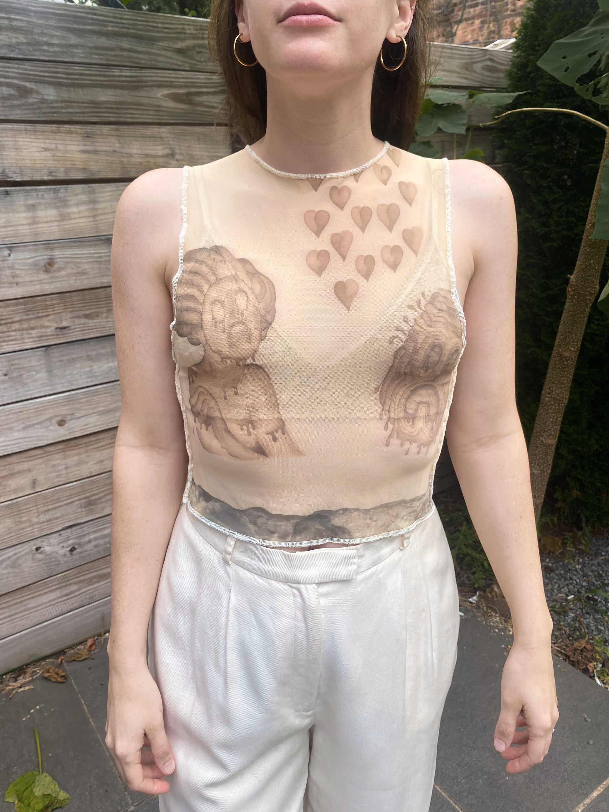 beige mesh crop top with despair faces print, front view