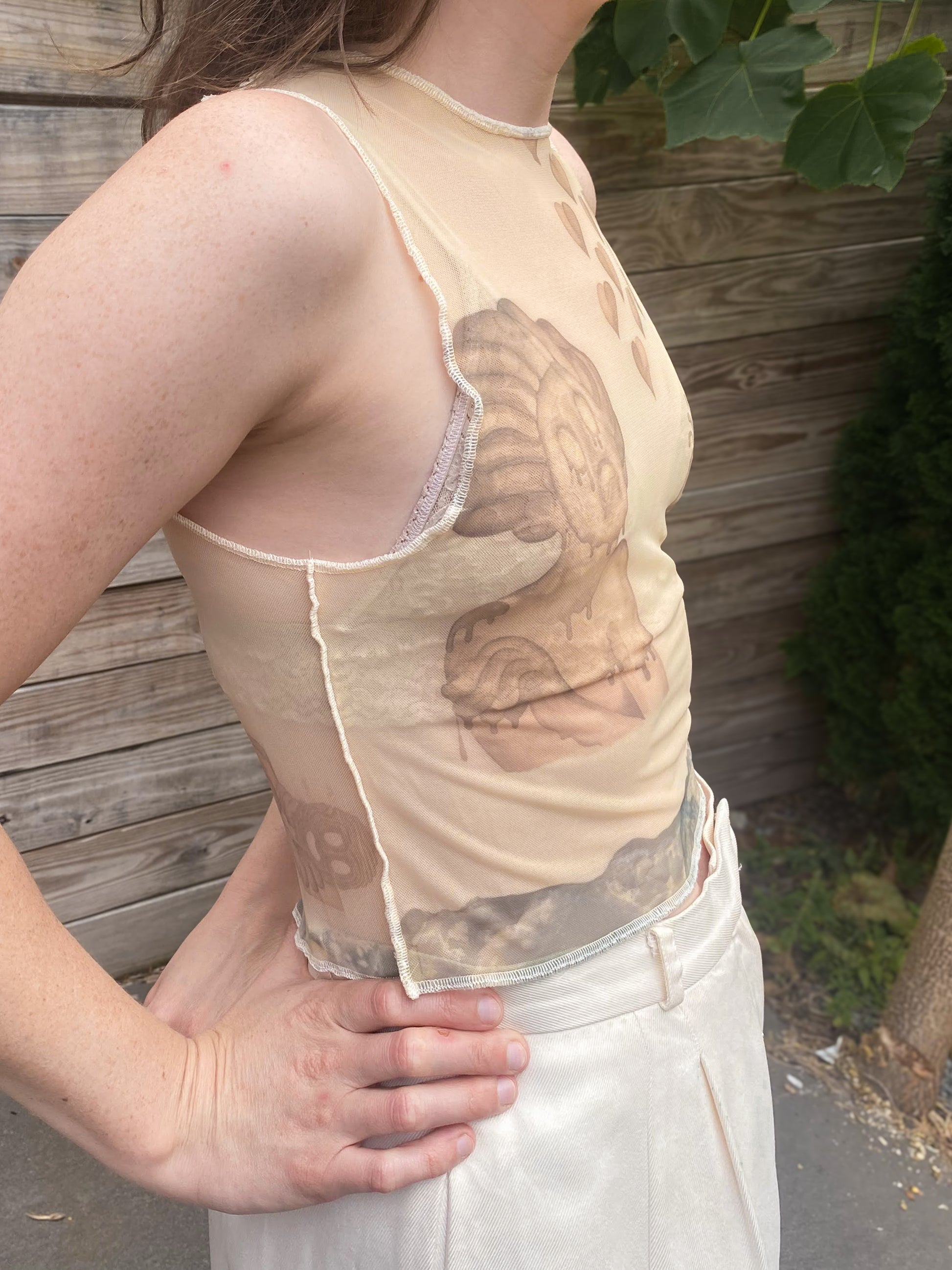 beige mesh crop top with despair faces print, side view