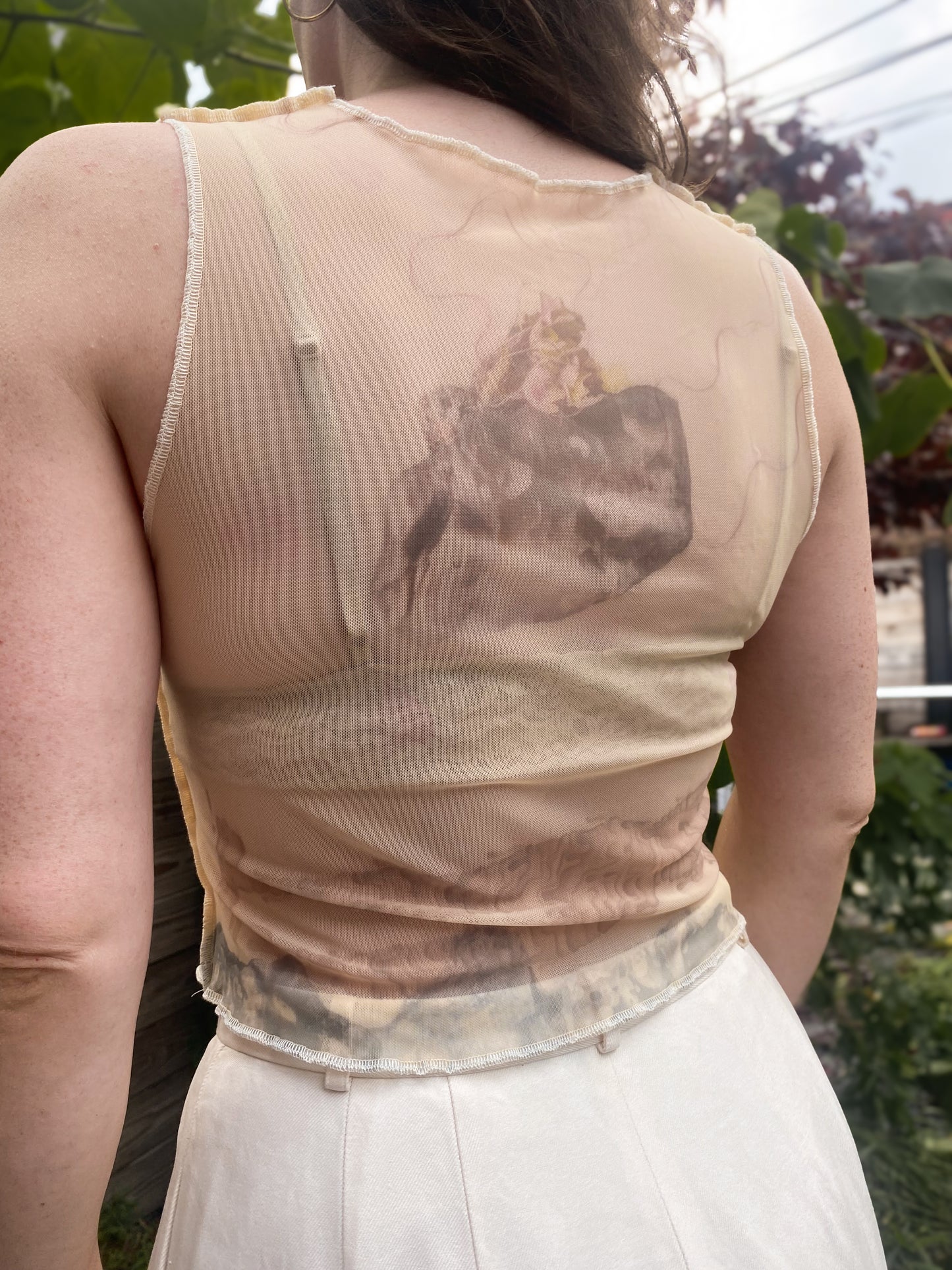 beige mesh crop top with despair faces print, back view